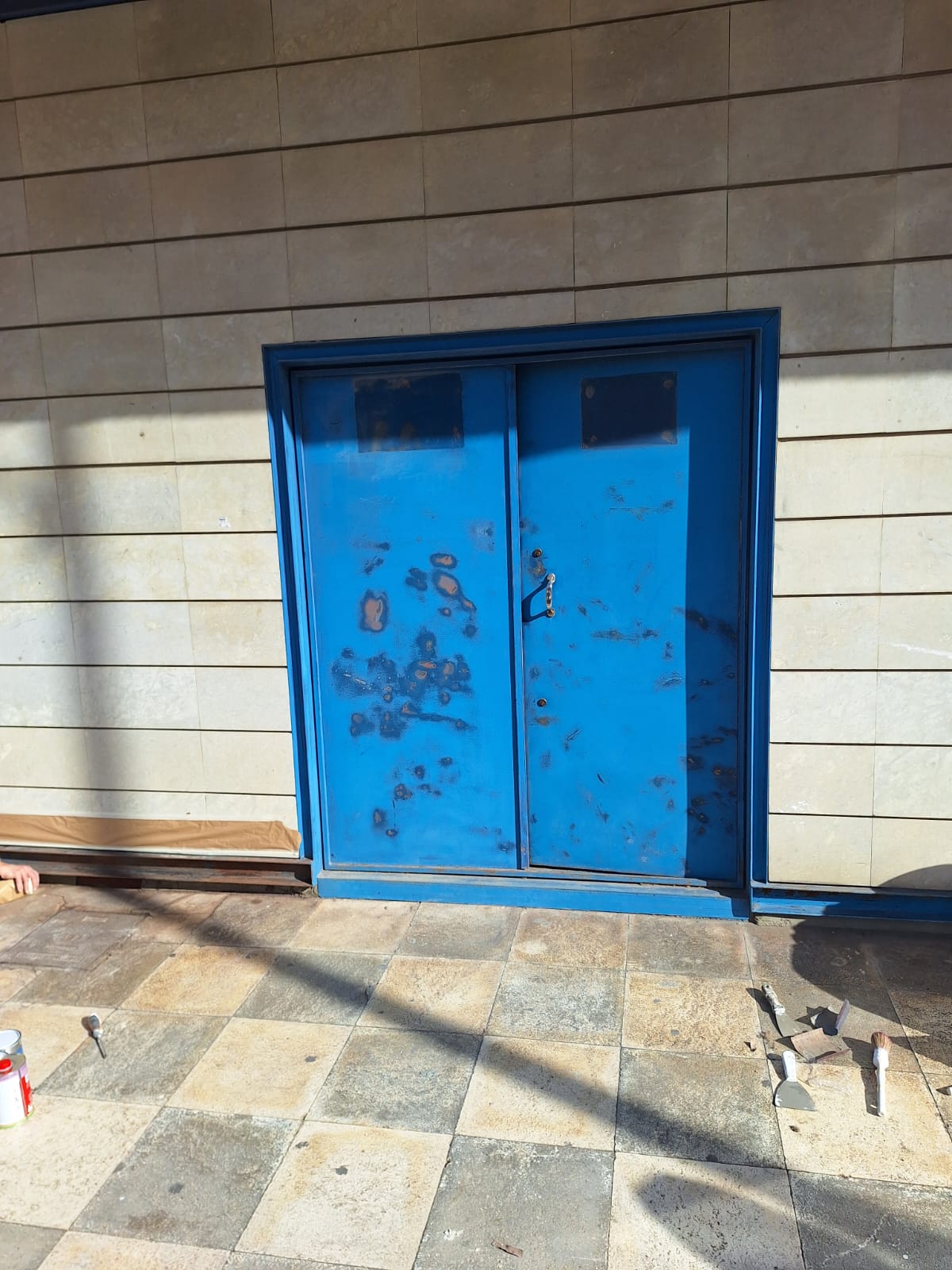 Puerta metálica exterior con desgaste y pérdida de acabado antes del repintado